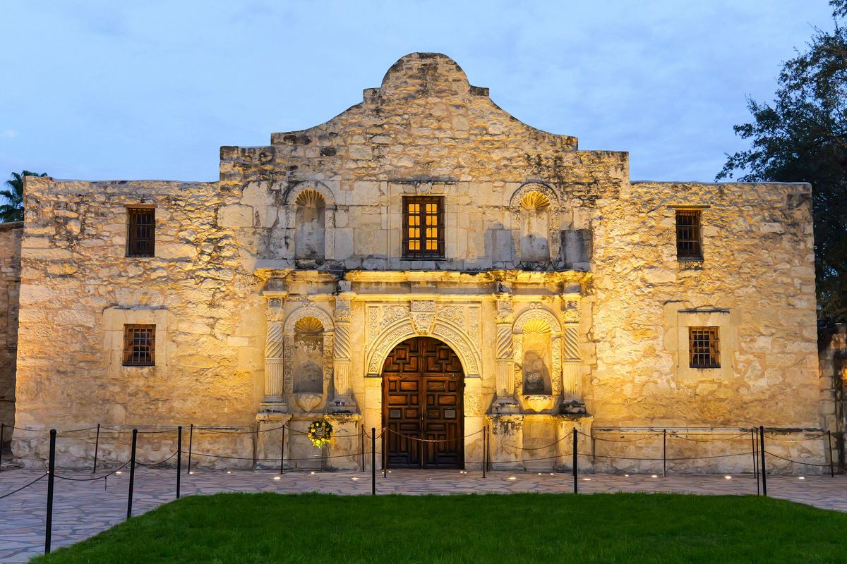 The Alamo facade lit warmly at dusk
