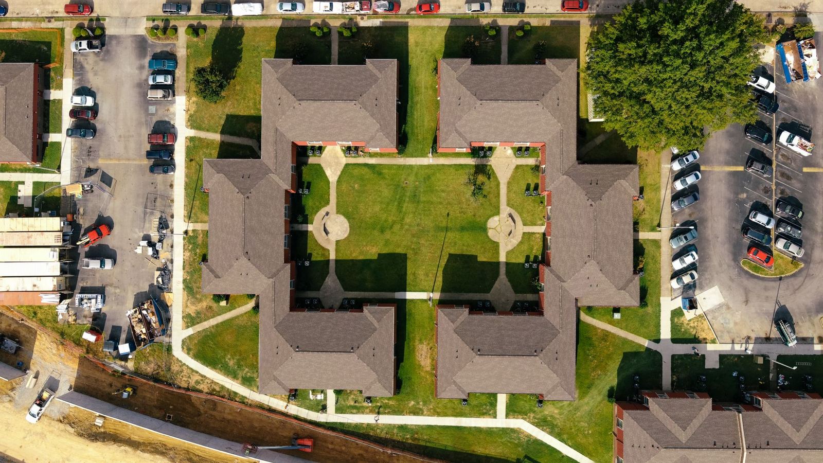 Aerial view of a new apartment complex with lawns and surrounding parking