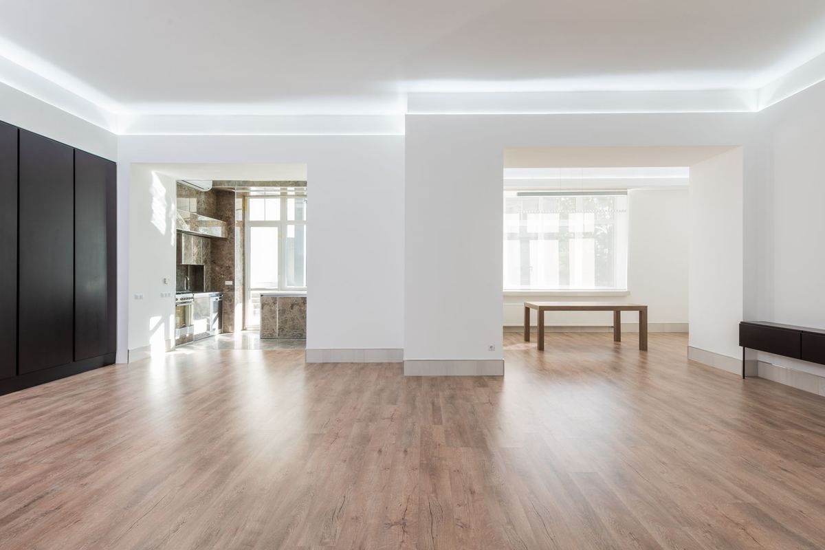 Bright connected empty rooms with wood floors and tall windows