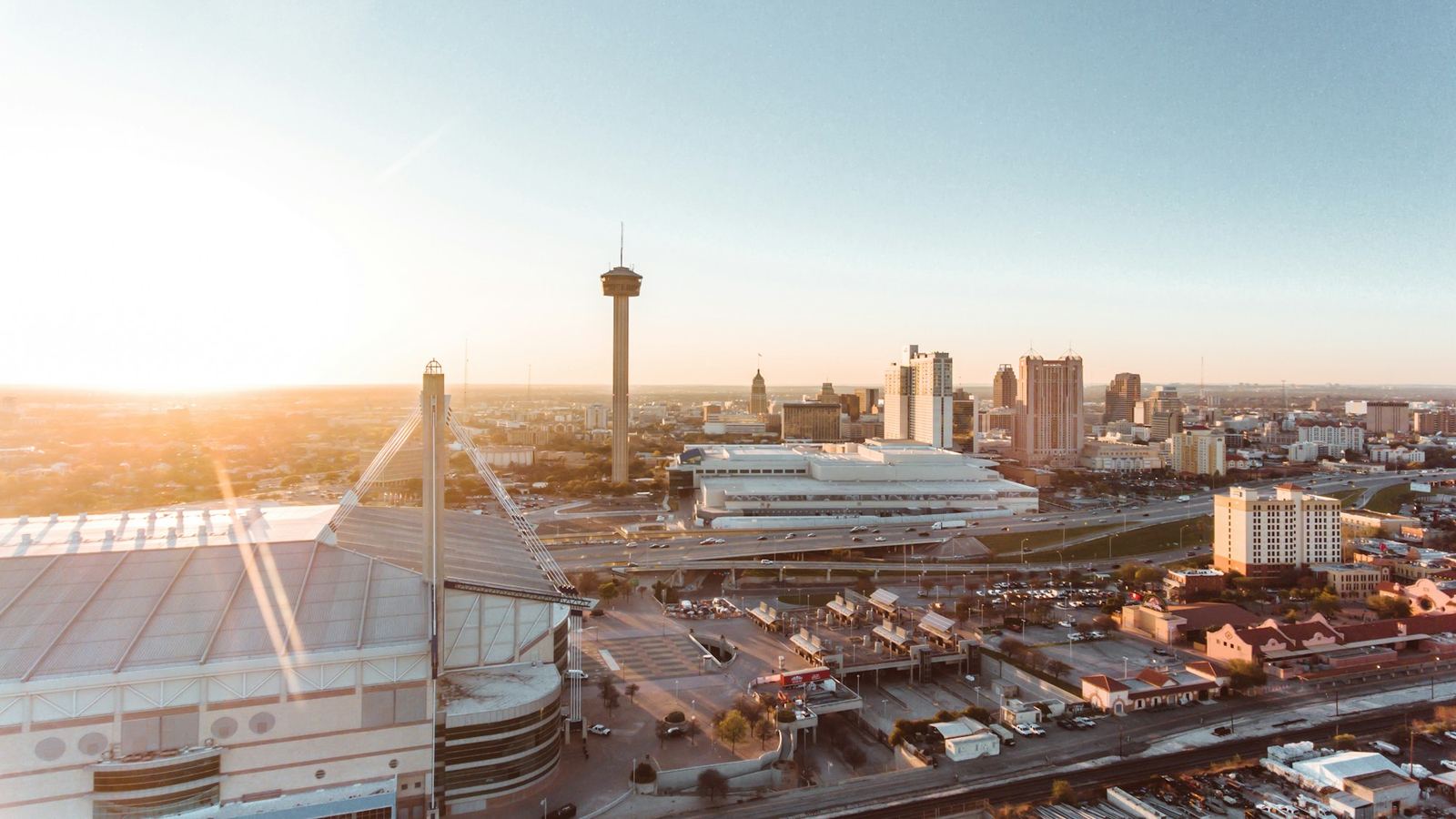 Aerial view of the Alamodome, the Tower of the Americas and downtown San Antonio at sunrise
