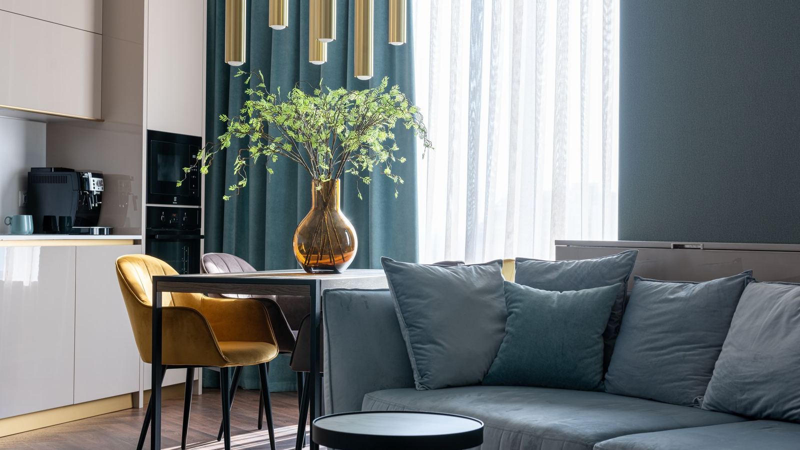 Furnished apartment living area with a teal sofa and a dining table
