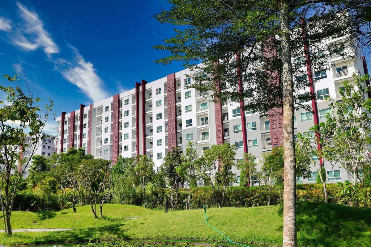 Garden apartment buildings set behind an open lawn and trees