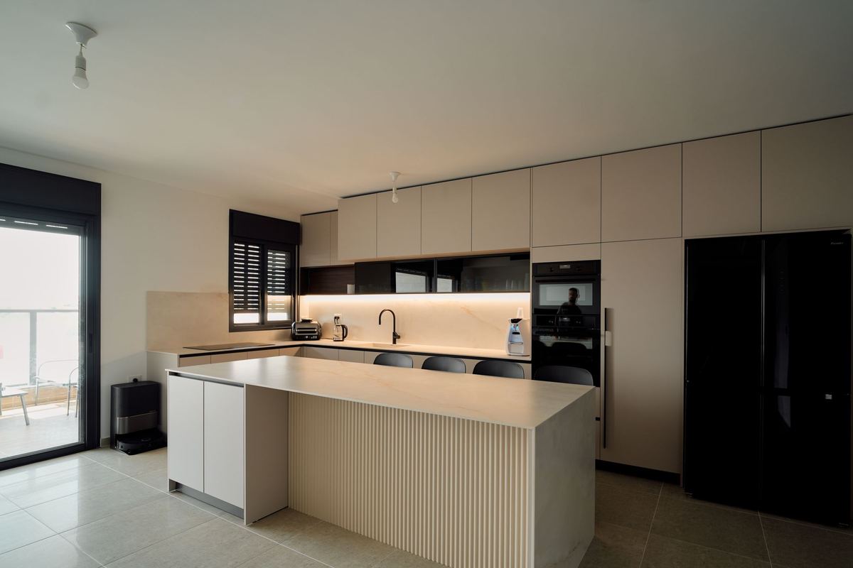 Glossy minimalist kitchen with a long island and integrated appliances