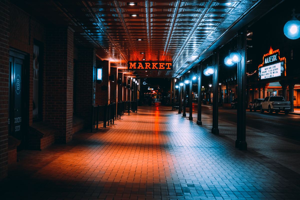 Covered sidewalk arcade and theatre marquee on a downtown San Antonio street at night