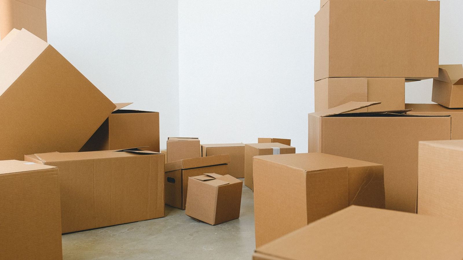 Cardboard moving boxes stacked in an empty room